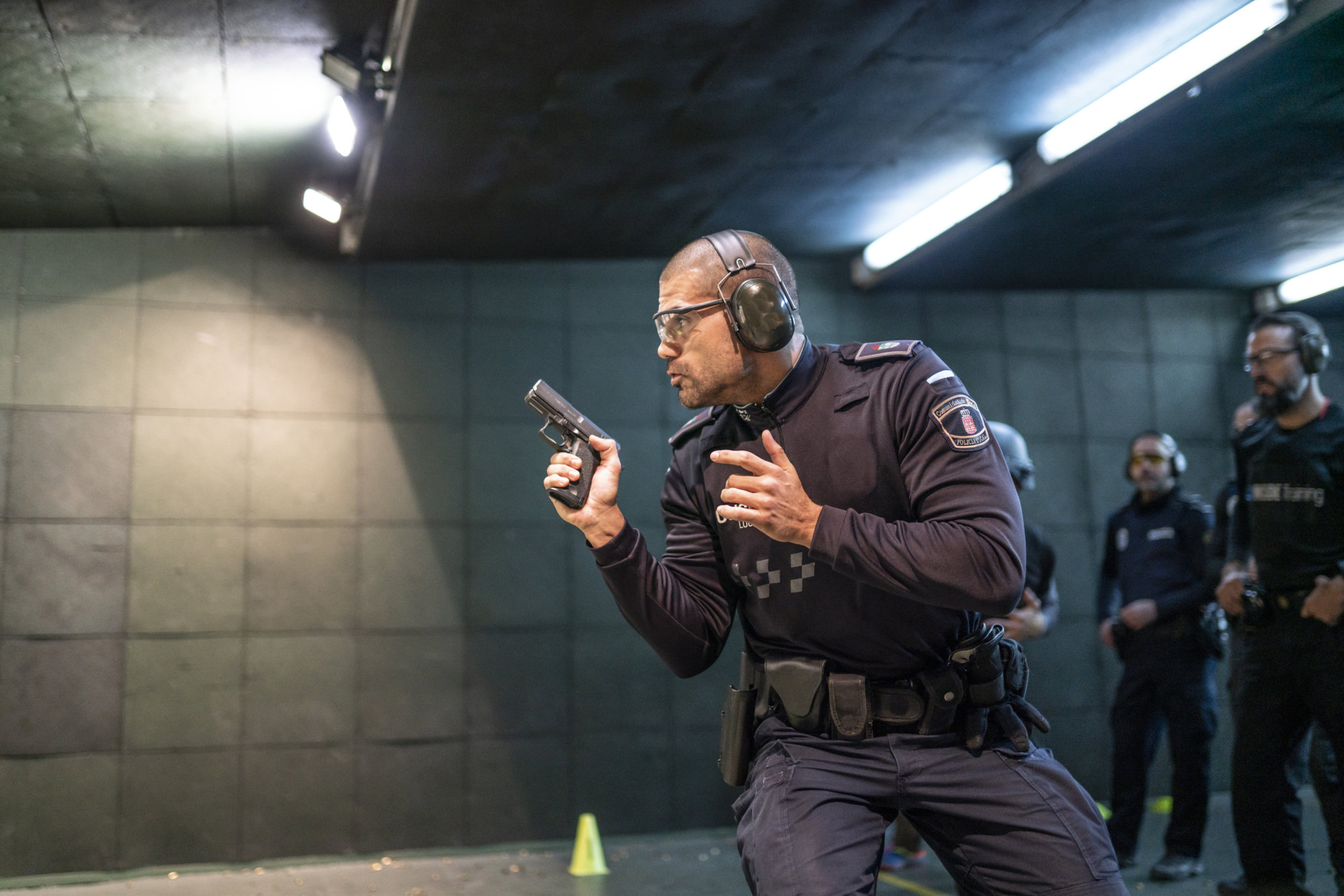 Police training in shooting gallery with short weapon.