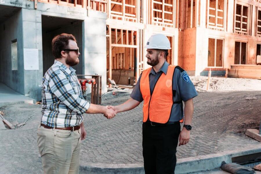 A security guard greeting a contractor at a work site