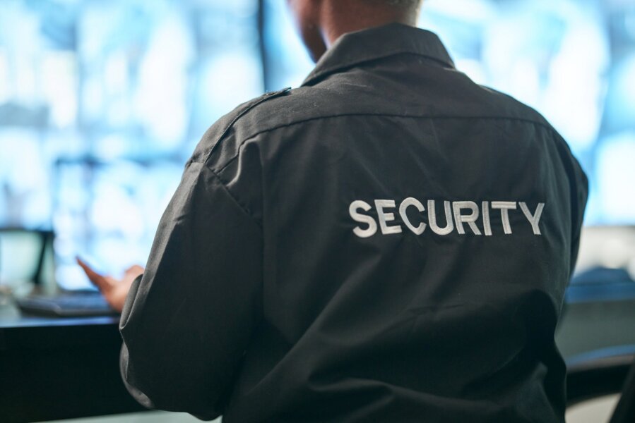 A corporate security guard sits at the front desk while providing office building security services.