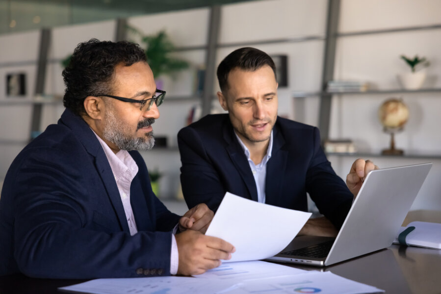 Alt text: Business professionals reviewing security service documentation during a meeting. 