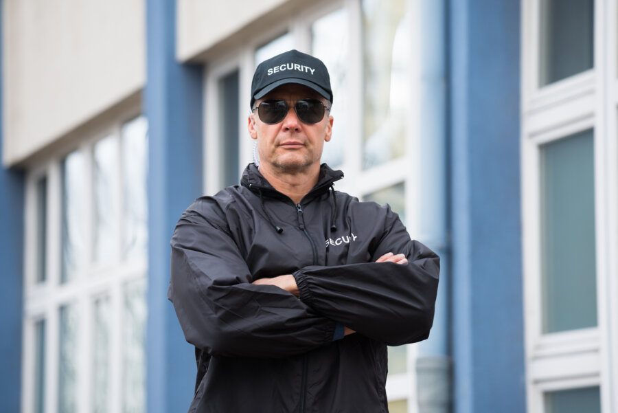 Security guard standing outside a commercial office building.